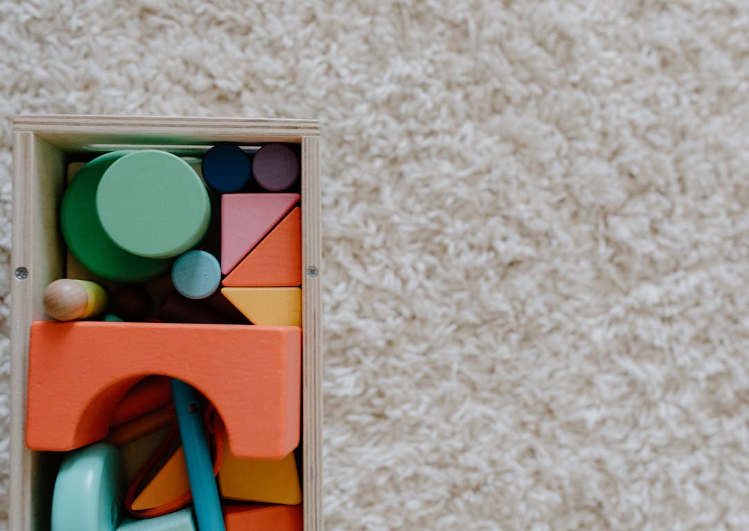 A set of colorful wooden blocks on a carpet, ideal for children's creative play.