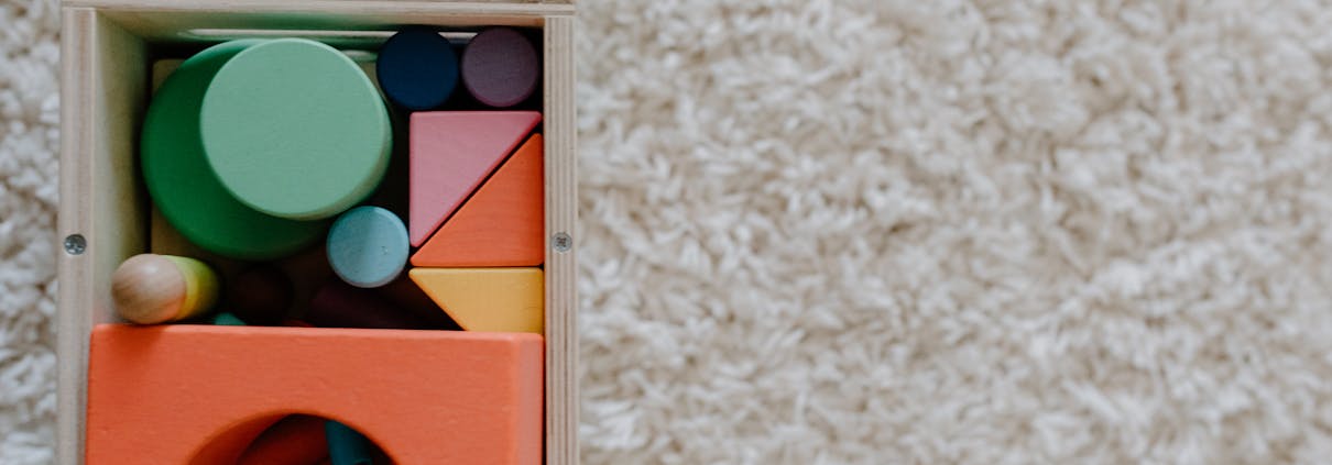 A set of colorful wooden blocks on a carpet, ideal for children's creative play.